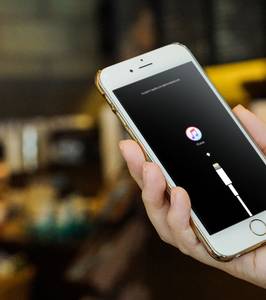 iPhone in hand with Recovery Mode prompt showing