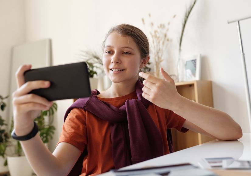 Red Shirt girl taking selfie and pointing while smiling