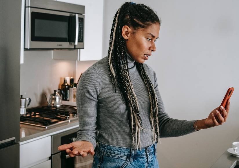 Lady in Kitchen Irritated with Cell Phone