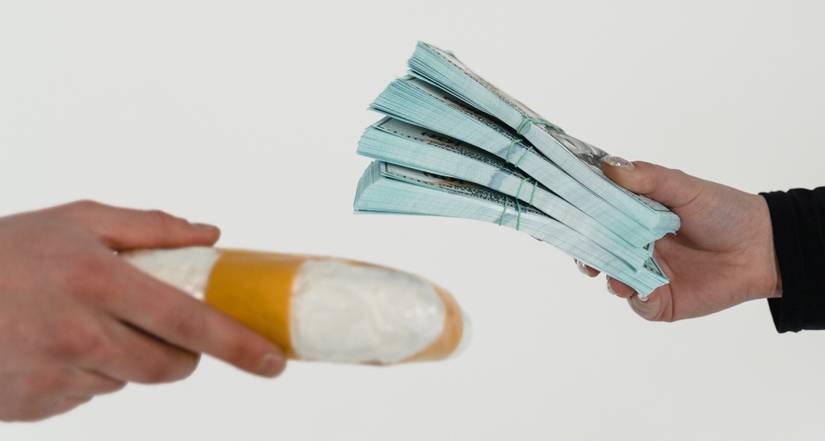 hands exchanging hard drugs and money