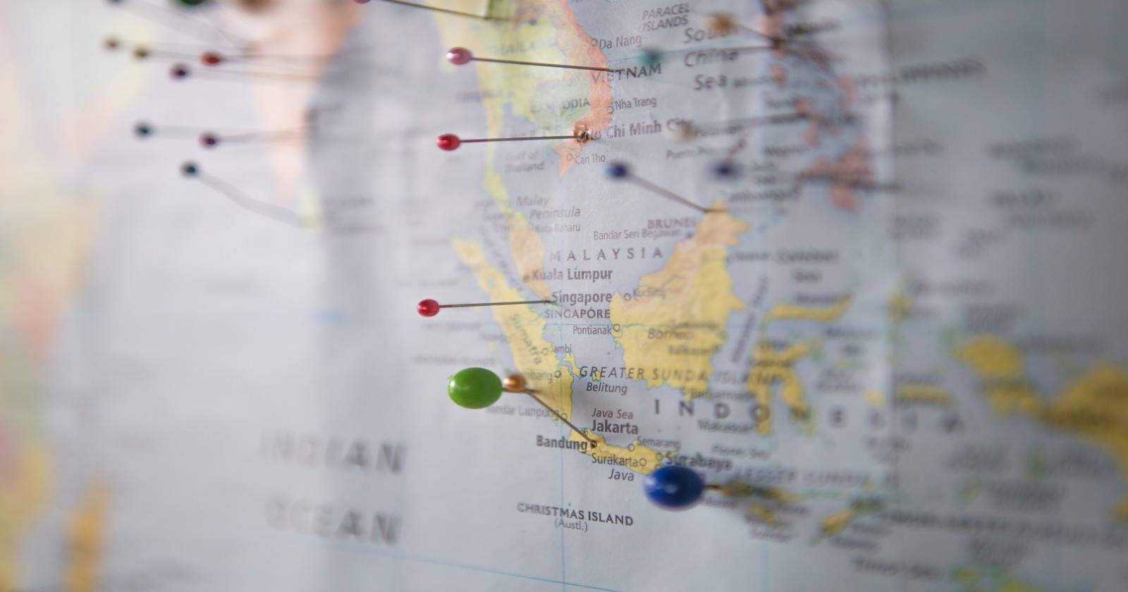 A world map with pins stuck in it at various locations