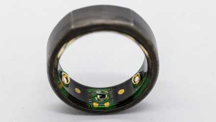 A close up shot of an Oura smart ring showing the electronic sensors inside