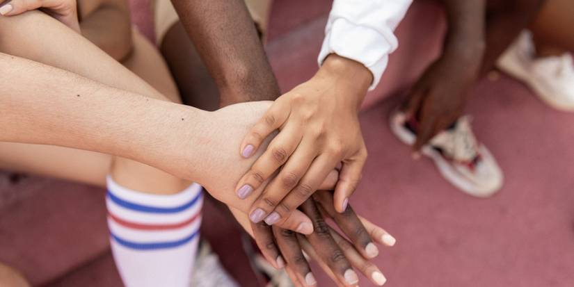 A photo of teammates putting hands together 