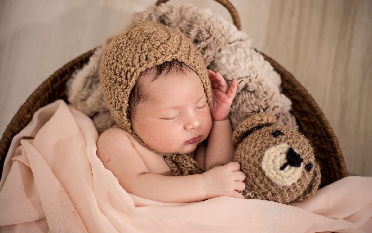Bebê usando gorro marrom enquanto dorme