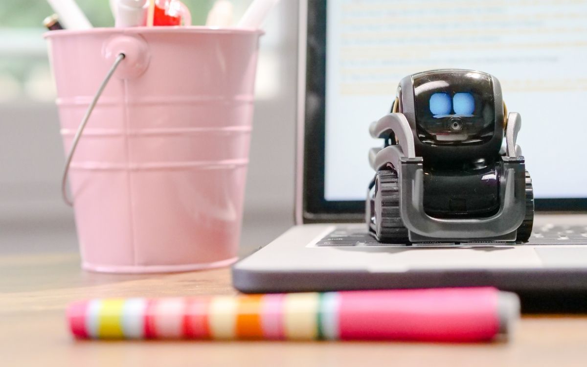 Robô de brinquedo miniatura em cima do teclado do laptop