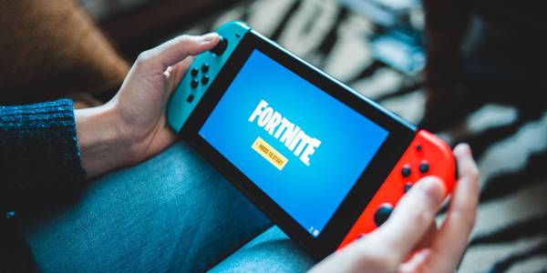 A Nintendo Switch in handheld mode showing the Fortnite logo