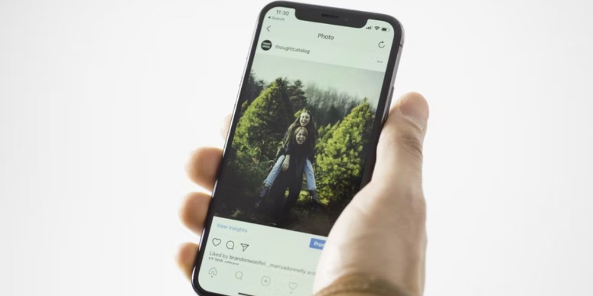 person holding iphone showing instagram post 