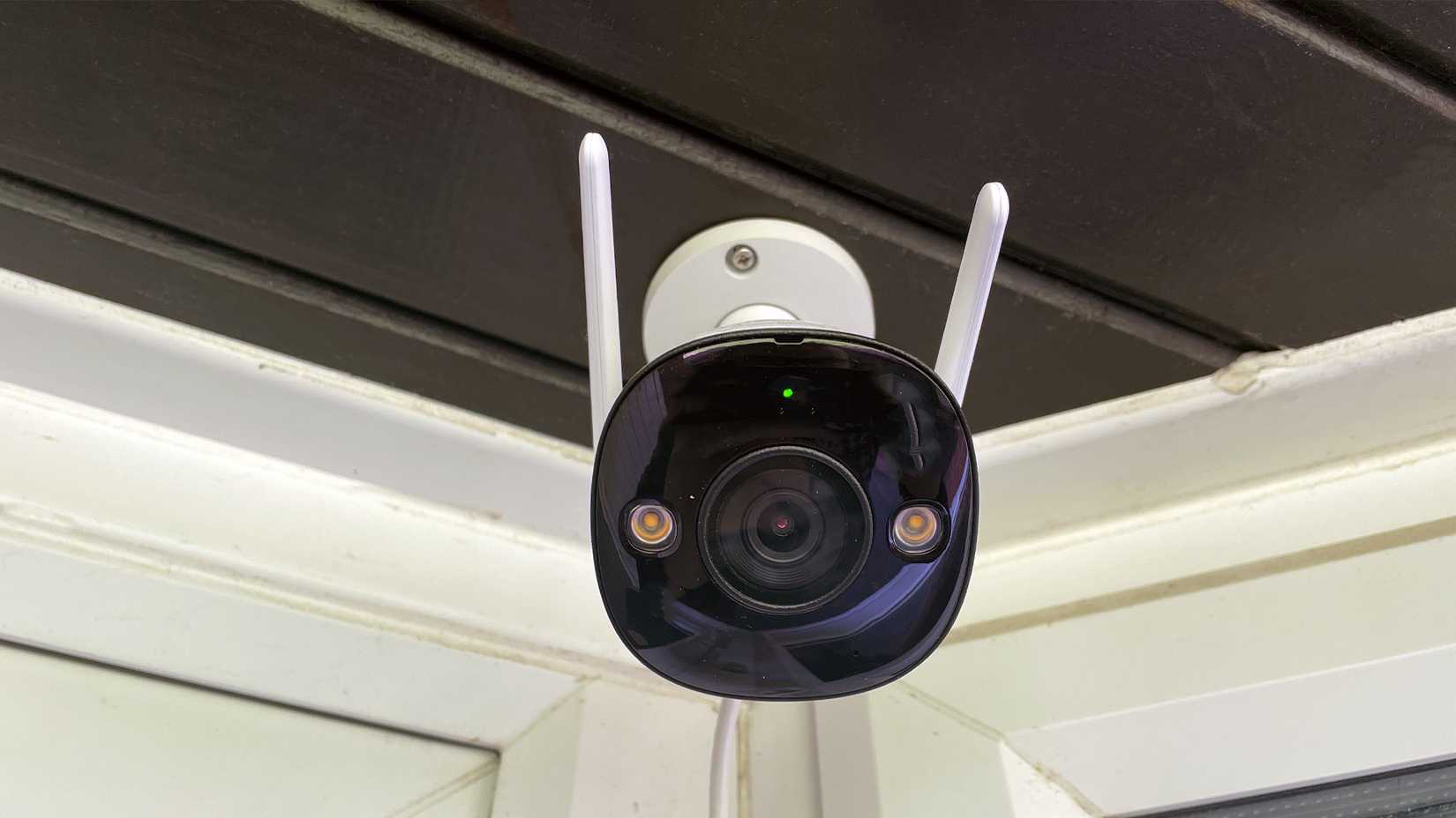 Defender Guard Pro 2K Wi-Fi Security Camera on Black Wooden Porch Front Angle