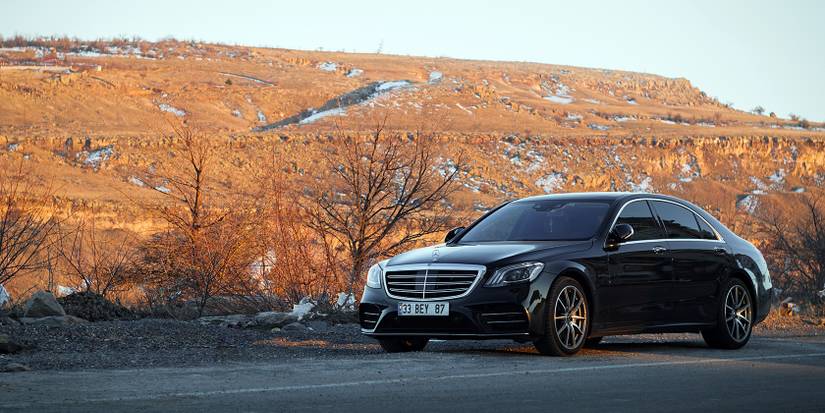 A Mercedes Benz S400 BlueHYBRID parked near a national park