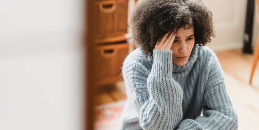 A sad-looking woman holding her head