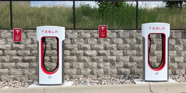 tesla supercharger with two red and white charging stations