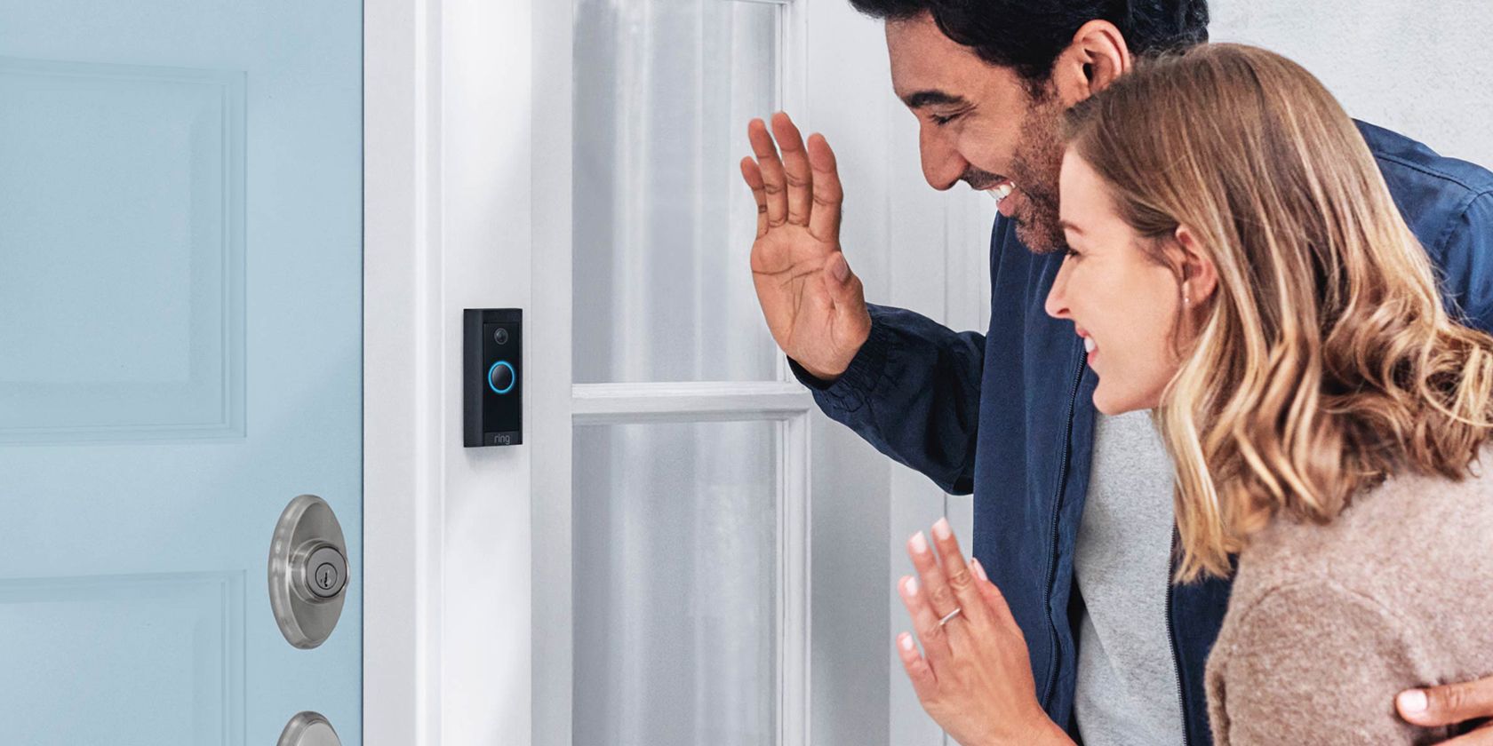 A couple waving to a Ring Video Doorbell