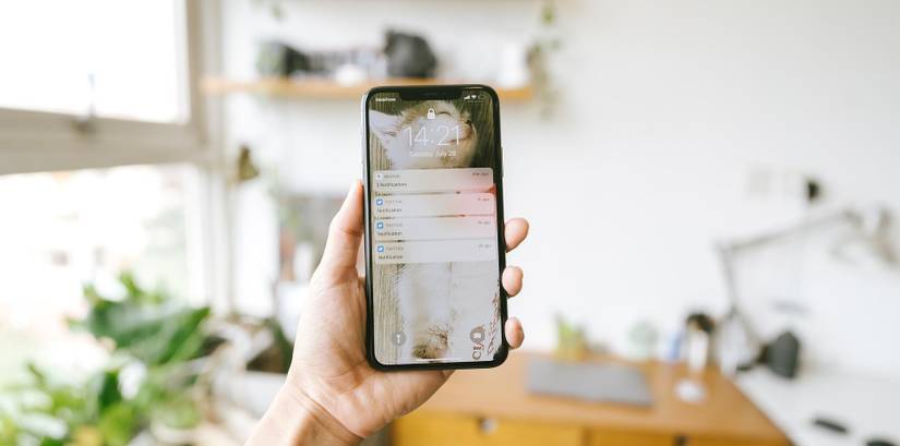 person holding smartphone displaying lock screen 