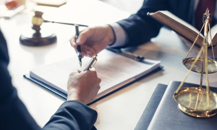 Two businessmen holding pens over a document
