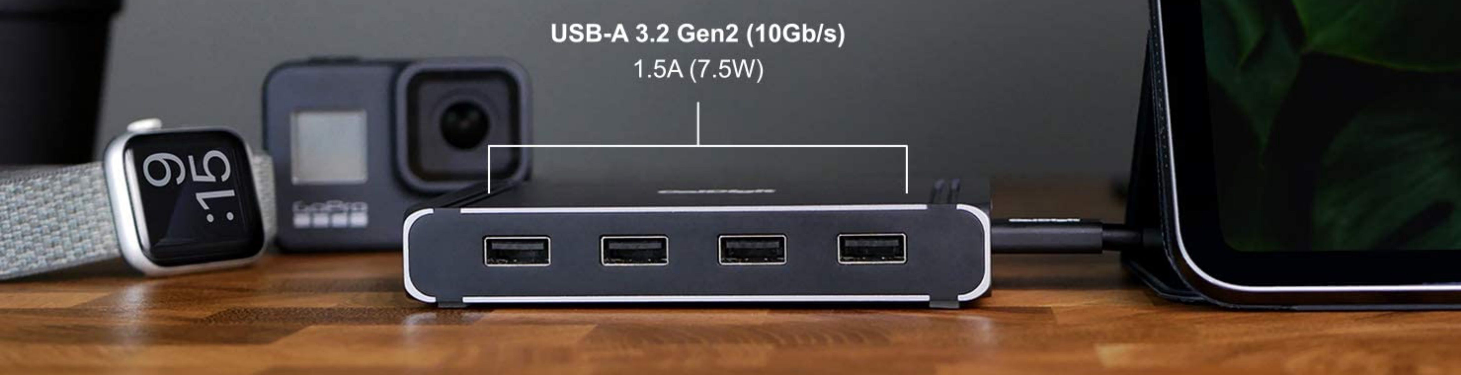 Face shot of CalDigit Thunderbolt 4 Element hub displaying four USB-A-Ports on a table with various devices beside it