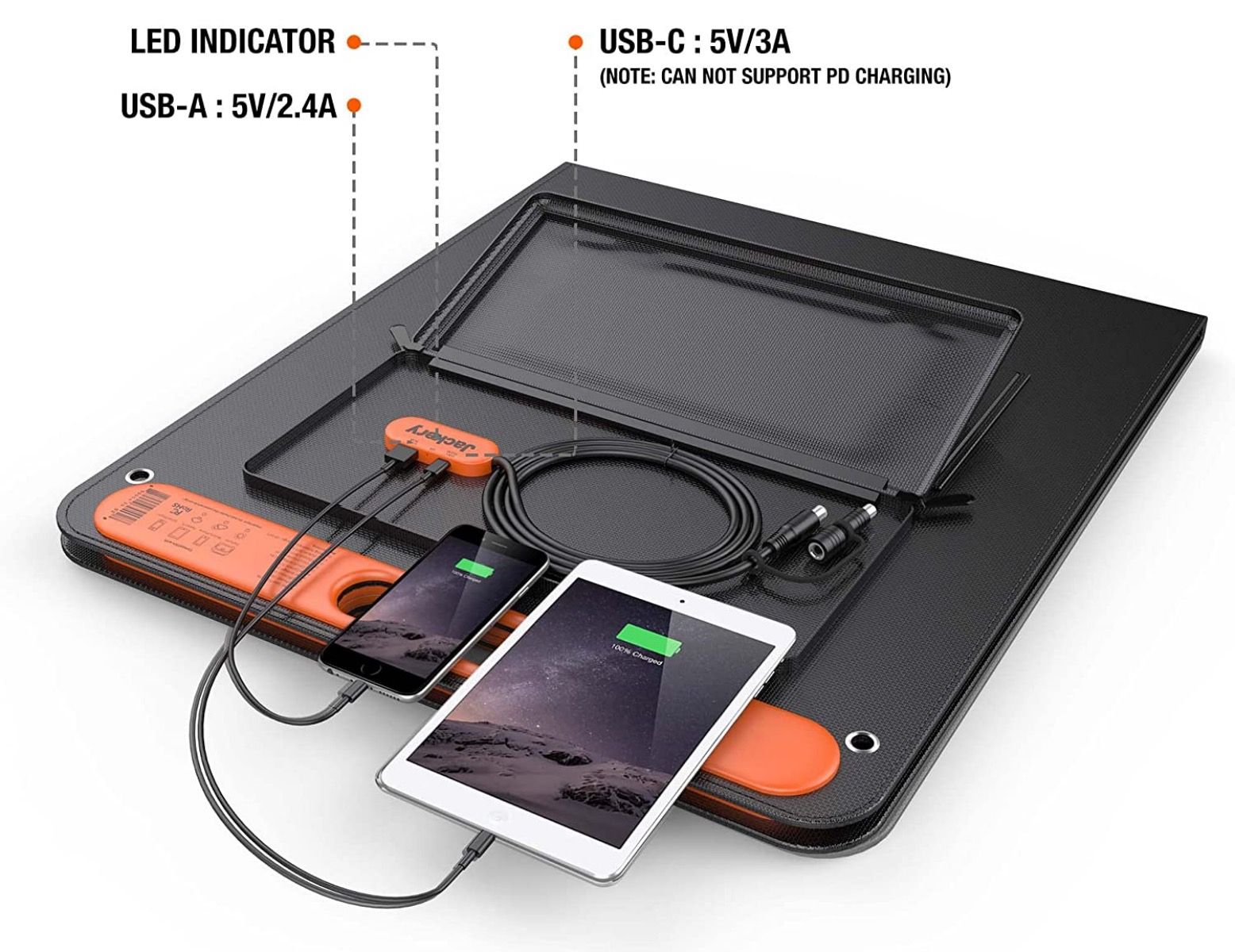 Jackery SolarSaga 100W lying flat and charging cellphone and tablet via USB ports