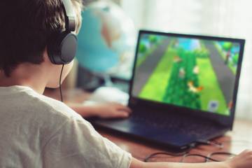 boy playing game on laptop
