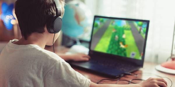 boy playing game on laptop