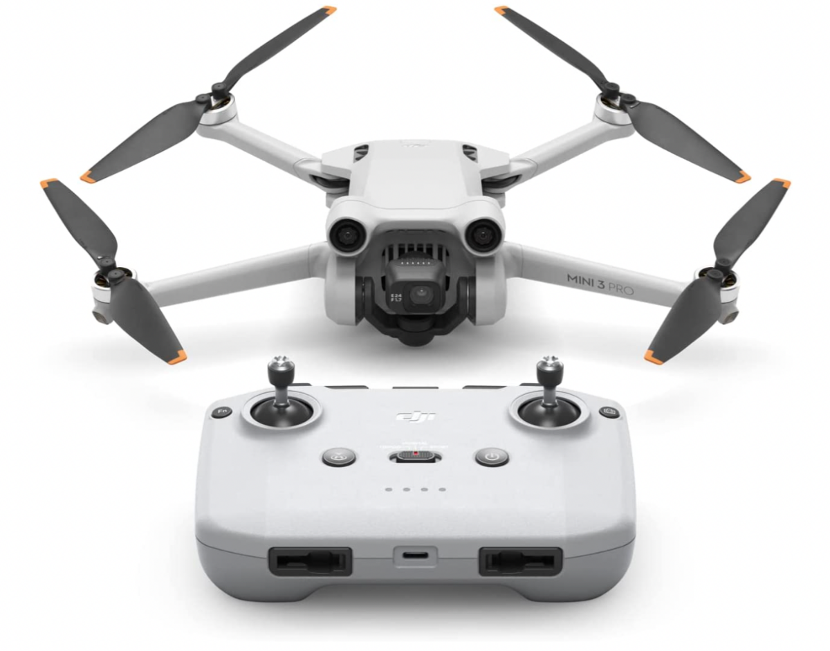 A full shot of the DJI Mini Pro 3 unfolded with propellors sitting behind its remote control