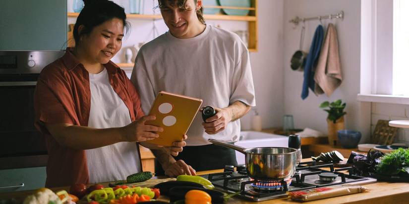 A couple looking at a tablet device in the kitchen