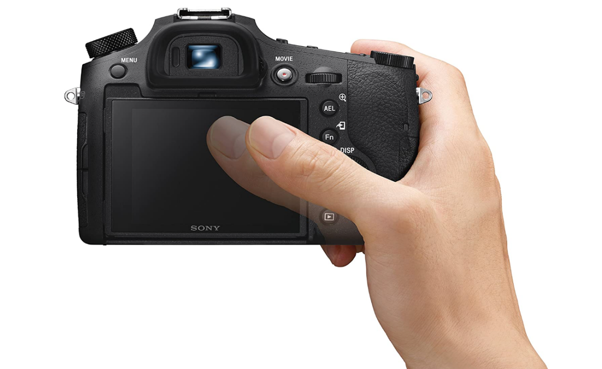 تصویری از Sony Cybershot RX10 IV در دست شخصی با صفحه نمایش خالی نمایش داده می شود