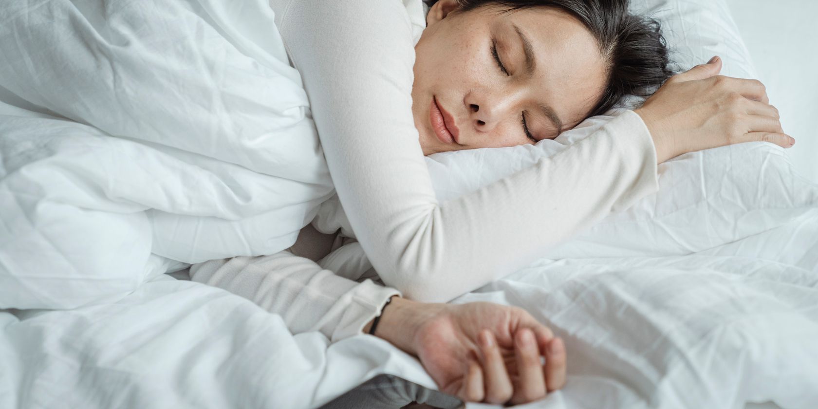 a woman asleep in bed with a phone next to her