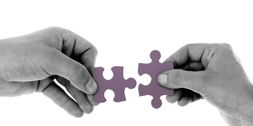 Hands holding up a puzzle piece each