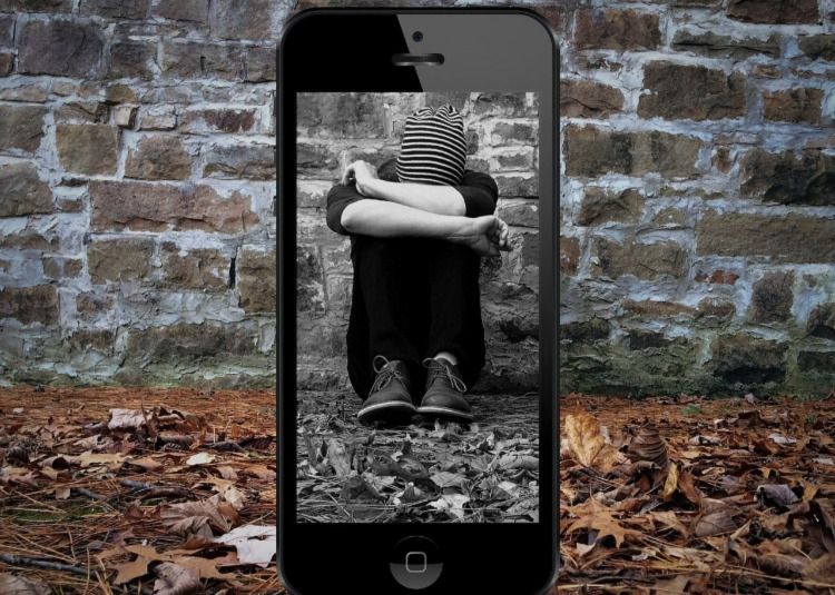 Sad person framed by phone