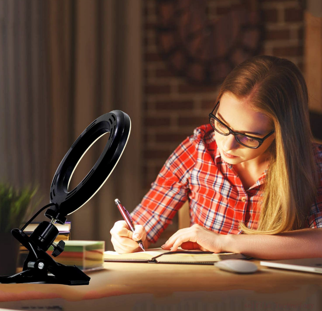 An image showing a woman using a Selfila Clip-On Ring Light as a desk lamp while she studies