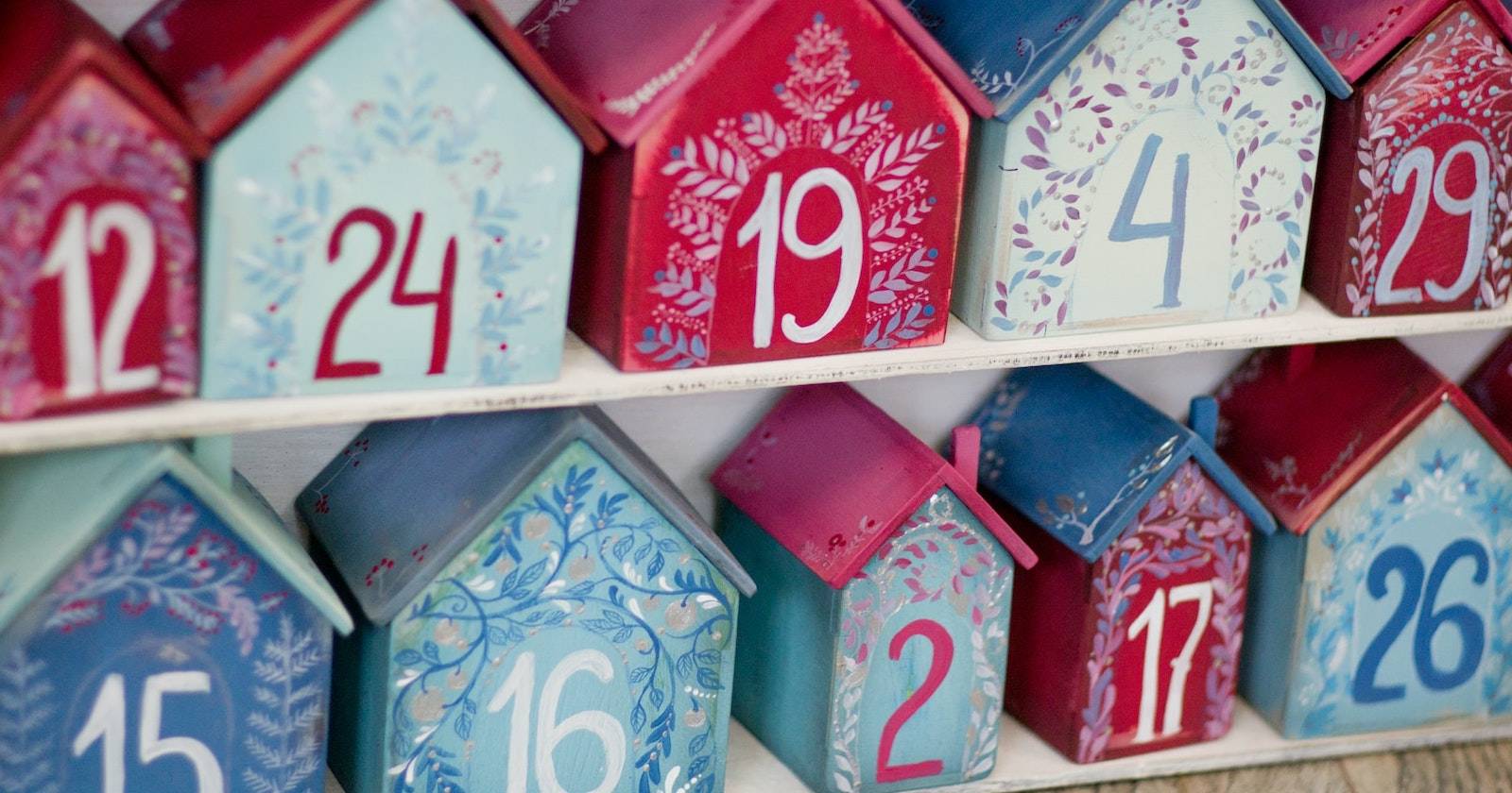 An advent calendar made from numbered wooden boxes painted red and blue.