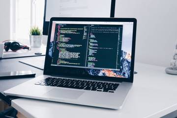 An open laptop with a code editor showing on screen