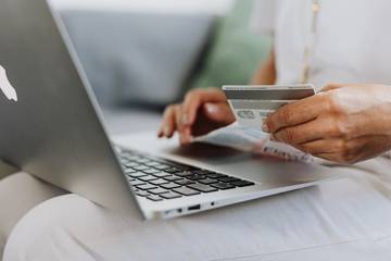 A woman holding a credit card with a Mac in her lap-1