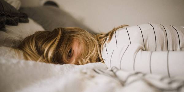 A person trying to sleep on a bed