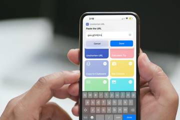person holding iphone showing shortcuts app
