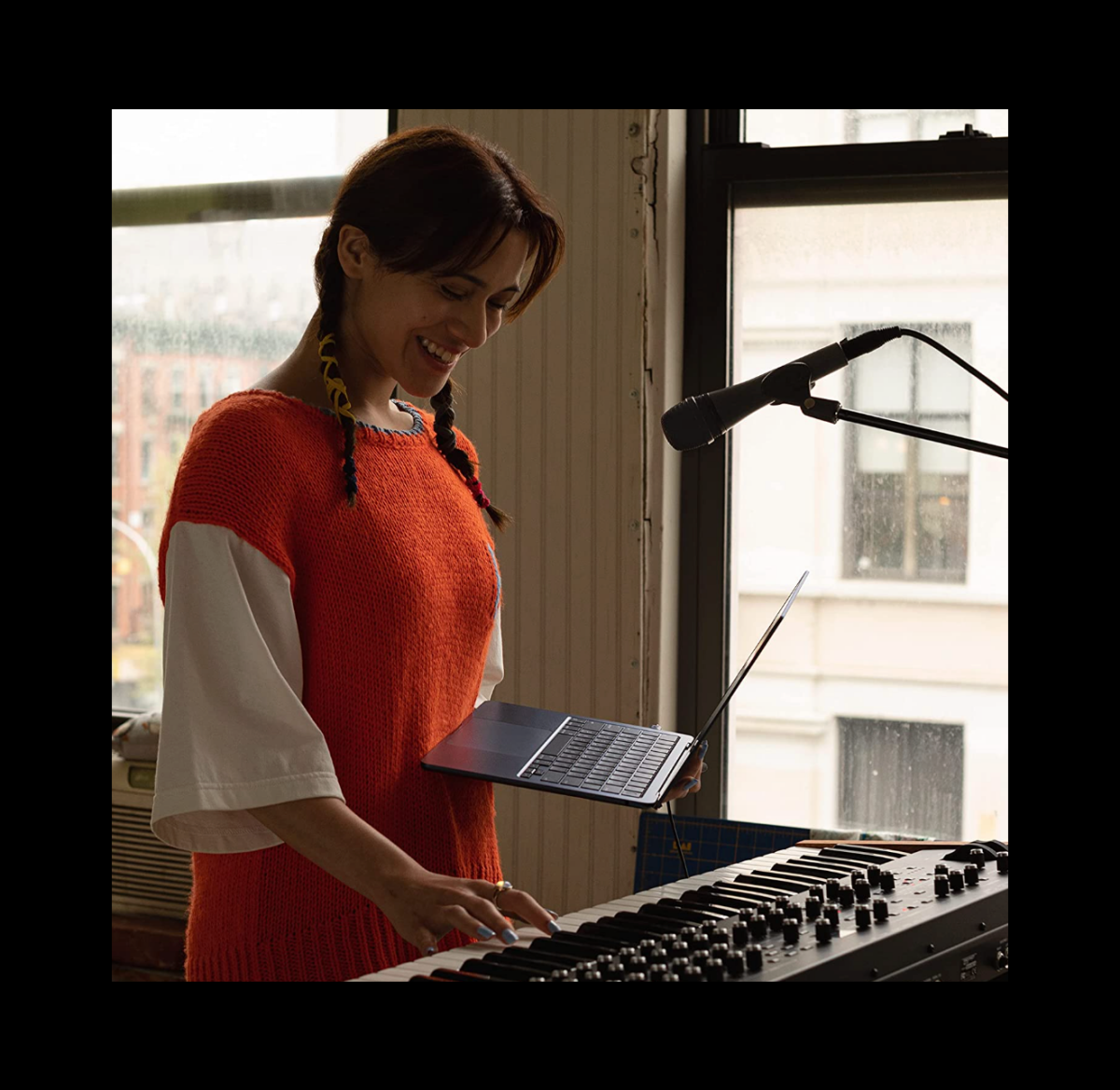 A woman using a MacBook Air with M2 chip to produce music