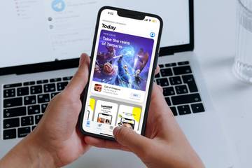 hand holding iphone showing app store today tab