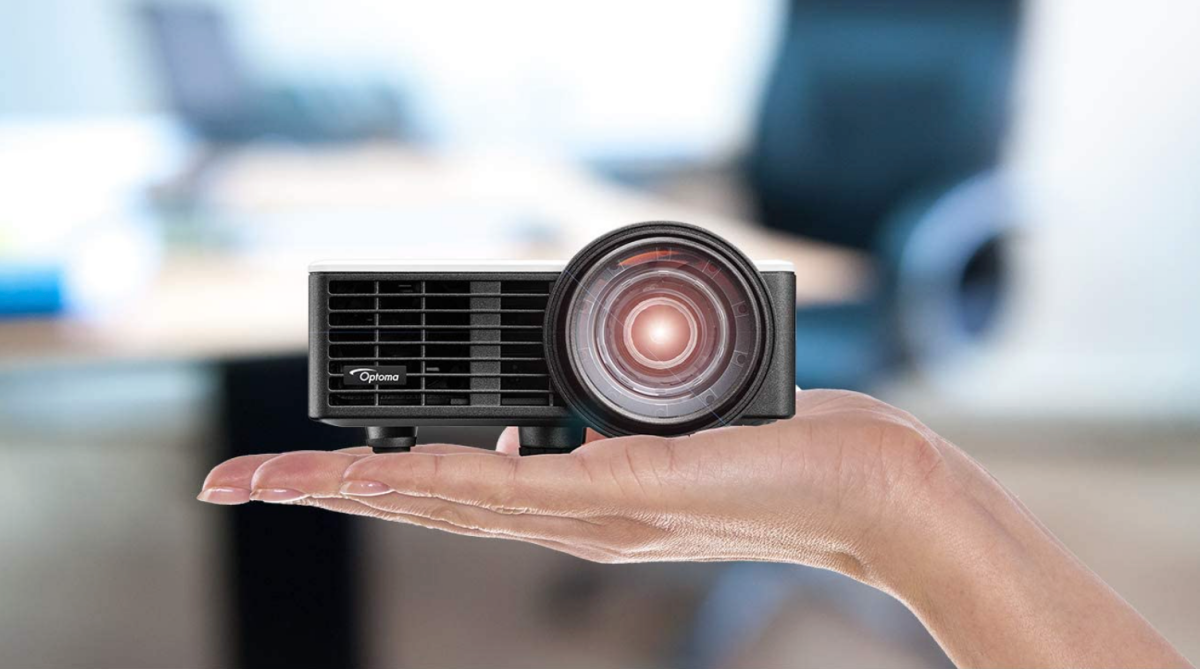 An Optoma ML750ST Ultra-Compact Short-Throw LED Projector in the palm of a woman's hand