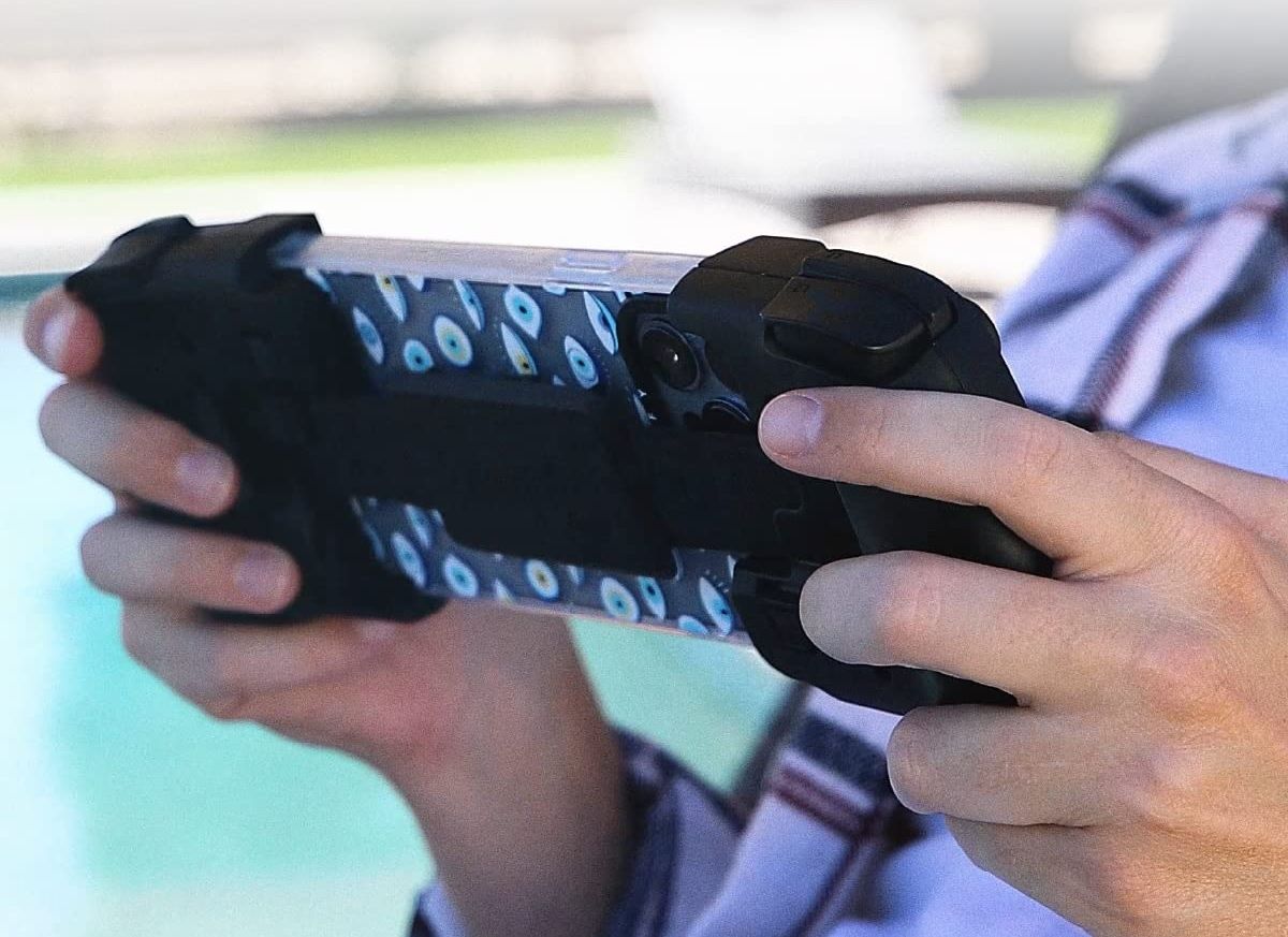 A person using the Gamevice FLEX Mobile Game Controller with their mobile device