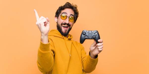 man in yellow hoodie point in the air holding a game controller