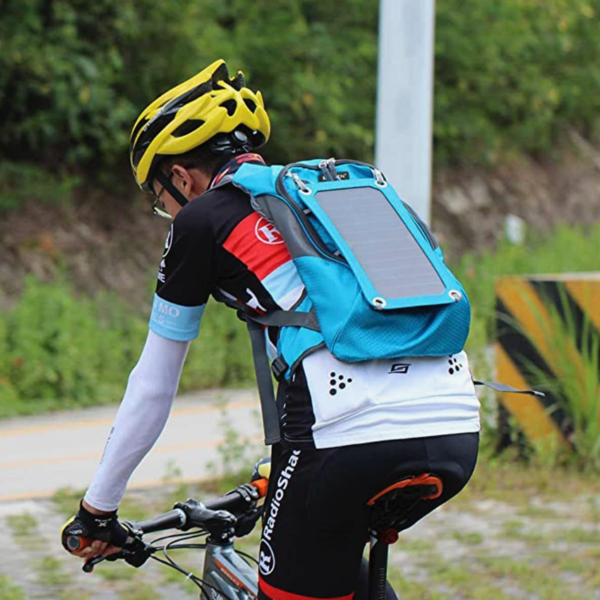 A cyclist wearing a blue ECEEN 7W Solar Hydration Backpack