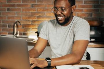 man using laptop smiles