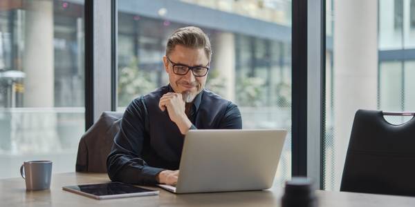 photo of a man working on his laptop in an office building