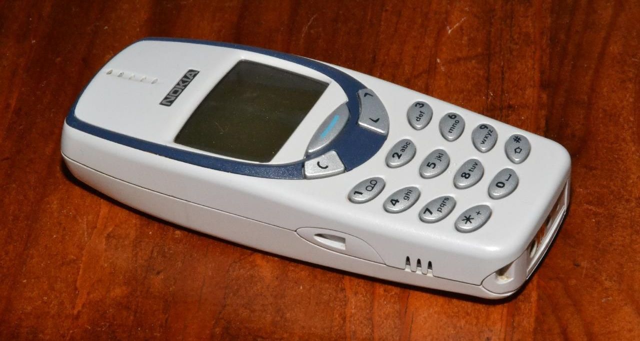 image of old white nokia phone on wooden surface