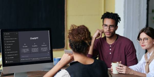 Three Employees Chatting With ChatGPT Open on Desktop