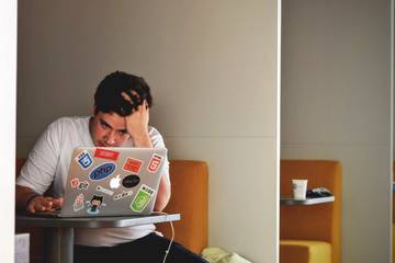 frustrated man uses laptop