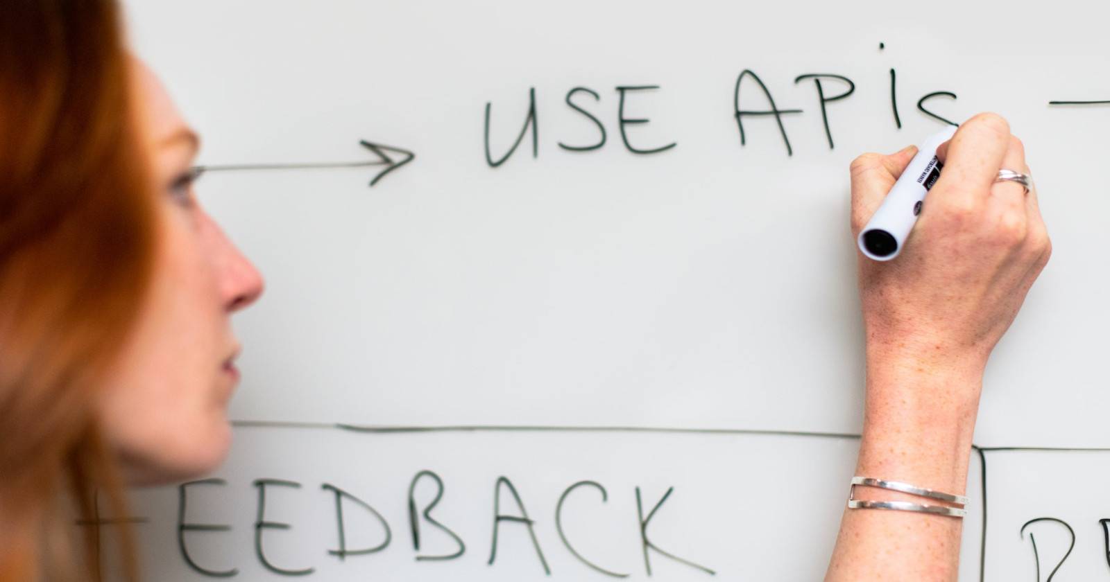 Lady writing use APIs on white board