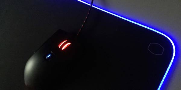 Gaming mouse resting on an RGB mousepad with blue lighting