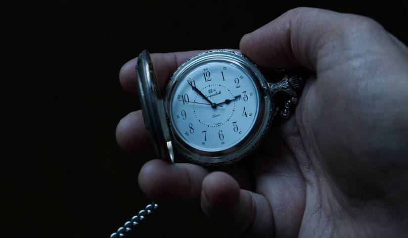 A hand holding a pocket watch