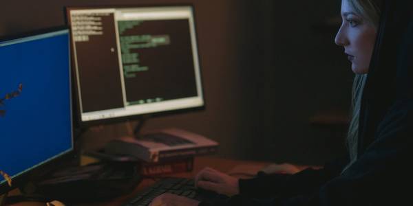 Woman operating a computer in a dark room