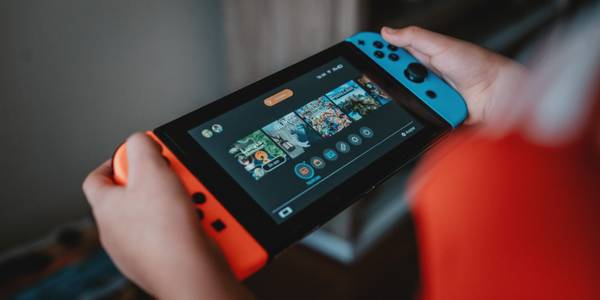 A photograph of someone playing a Nintendo Switch in handheld mode 